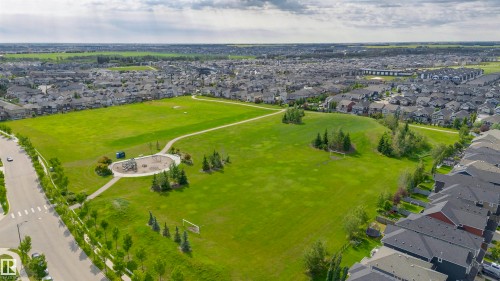 Expansive green space featuring recreational fields, paved walking paths, a dedicated playground area, and mature trees - 1235 164 Street, Edmonton, AB 
