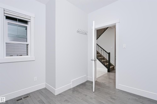 Room featuring wood-finish flooring, white baseboards, and neutral wall paint - 1235 164 Street, Edmonton, AB 
