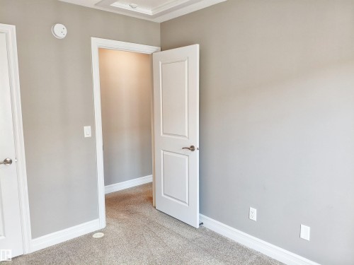 Carpeted room with light gray walls and white trim - 23 1508 105 Street, Edmonton, AB 