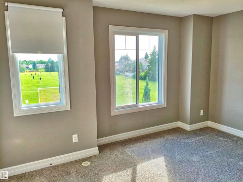 Neutral tone walls with white trim, featuring two windows - 23 1508 105 Street, Edmonton, AB 