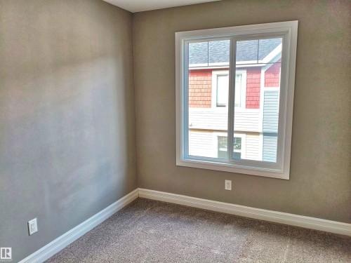 Bright interior space with a large window featuring white trim - 23 1508 105 Street, Edmonton, AB 