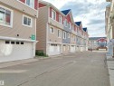 Row of townhomes featuring individual garages and multi-level facades - 23 1508 105 Street, Edmonton, AB 