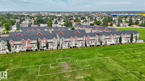 Contemporary multi-story townhomes with red and beige siding, dark shingled roofs, and white trim accents - #23 1508 105 St Nw, Edmonton, AB -  With View