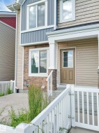 Multi-textured exterior featuring beige siding, blue vertical siding, and stone accents - 