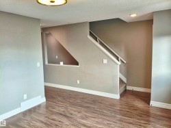 Interior space featuring wood-finish flooring, neutral wall paint, and white baseboards - 