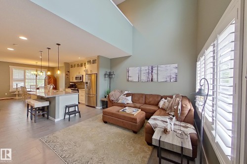Open-concept living space featuring high ceilings, wood-finish flooring, and white plantation shutters - 14412 98 Street, Edmonton, AB - Indoor Photo Showing Living Room