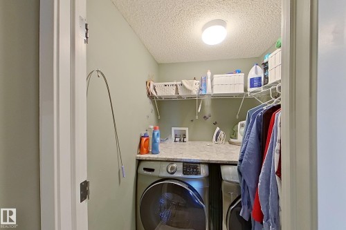 Dedicated laundry area featuring a built-in countertop, upper wire shelving, recessed lighting, and light green wall paint - 14412 98 Street, Edmonton, AB - Indoor Photo Showing Laundry Room