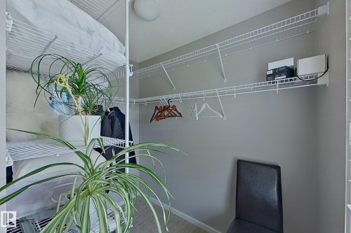 Efficient closet space featuring wire shelving systems, integrated hanging rods, light gray wall paint, and light-toned flooring - 14412 98 Street, Edmonton, AB - Indoor
