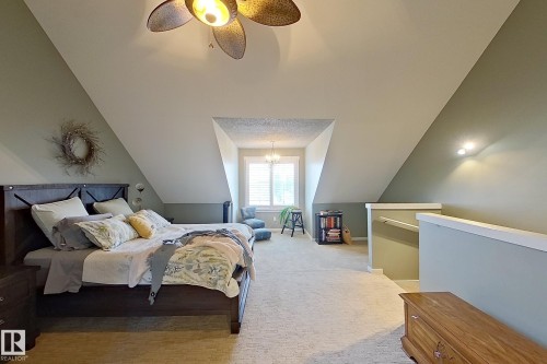 Carpeted room featuring sloped ceilings, two-tone wall paint, a window with plantation shutters, and a ceiling fan with integrated lighting - 14412 98 Street, Edmonton, AB - Indoor Photo Showing Bedroom