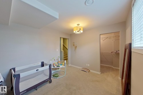 Carpeted room featuring a ceiling-mounted light fixture, recessed ceiling vent, and window with blinds - 14412 98 Street, Edmonton, AB - Indoor