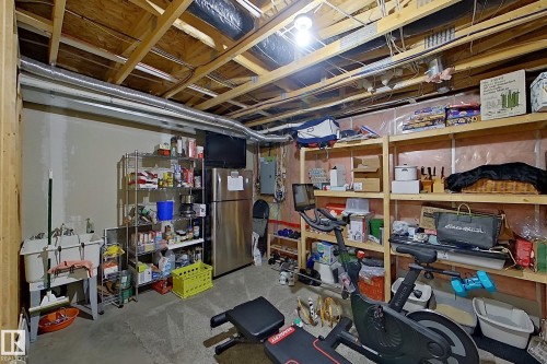 Unfinished basement featuring exposed ceiling joists, concrete flooring, and a utility sink - 14412 98 Street, Edmonton, AB - Indoor Photo Showing Basement