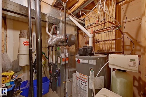 Utility space featuring a furnace, water heater, water softener system, and an intricate copper piping network - 14412 98 Street, Edmonton, AB - Indoor Photo Showing Basement