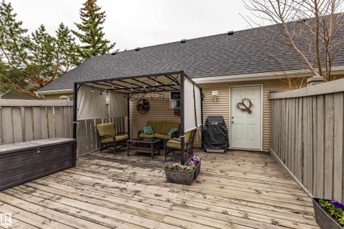 Expansive outdoor deck area featuring a gazebo with a fabric canopy, a solid exterior door, and vertical wooden fencing - 14412 98 Street, Edmonton, AB - Outdoor With Deck Patio Veranda With Exterior