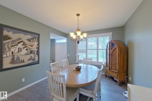 Dining area with neutral wall color, tile flooring, and a chandelier light fixture - 14412 98 Street, Edmonton, AB - Indoor Photo Showing Dining Room