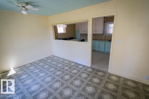 Room featuring patterned vinyl flooring, light-toned wall paneling, and a light blue ceiling - 5218 52 Ave, St. Paul Town, AB - Indoor Photo Showing Other Room