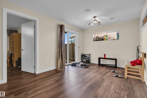 Spacious room featuring wood-finish flooring, light-toned walls, and white trim - 3071 Carpenter Landing Landing, Edmonton, AB 