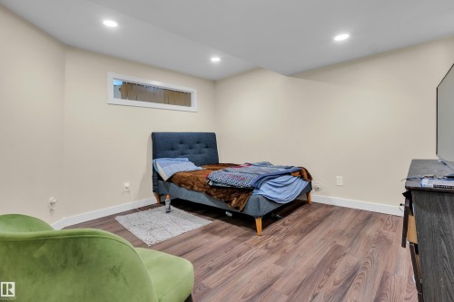 Spacious room featuring wood-finish flooring, recessed ceiling lighting, a high horizontal window, and neutral wall tones - 3071 Carpenter Landing Landing Sw, Edmonton, AB - Indoor Photo Showing Bedroom