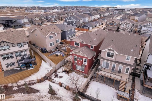Rear elevation of a residential property featuring a full-width upper deck with railing, a lower patio, and fenced backyard - 3071 Carpenter Landing Landing Sw, Edmonton, AB - Outdoor