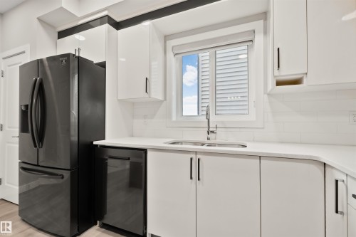 Contemporary kitchen featuring white cabinetry, light countertops, and a subway tile backsplash - 383 Charlesworth Drive, Edmonton, AB 