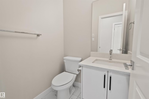 Bathroom vanity featuring a light-toned countertop, undermount sink, and contemporary chrome fixtures - 383 Charlesworth Drive, Edmonton, AB 