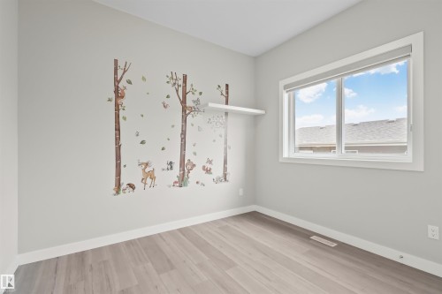Bright room with light gray walls and wood-finish flooring - 383 Charlesworth Drive, Edmonton, AB 