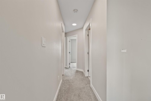 Hallway featuring light gray carpeting, white baseboards, light neutral wall paint, and recessed ceiling lighting - 383 Charlesworth Drive, Edmonton, AB 
