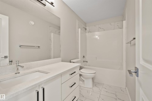 Bathroom featuring a white vanity with an integrated sink, polished chrome faucet, and quartz-finish countertop - 383 Charlesworth Drive, Edmonton, AB 