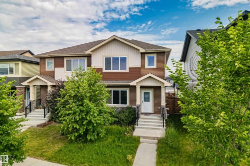 Two-story multi-family residence with a combined siding exterior and stone accents - 383 Charlesworth Drive, Edmonton, AB 
