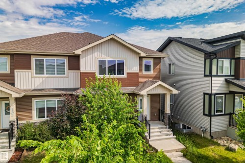 Contemporary multi-story residence featuring a covered front entry, multi-toned horizontal siding, and prominent windows with white trim - 383 Charlesworth Drive, Edmonton, AB 
