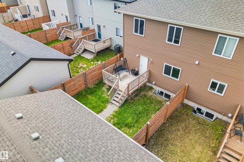 Private backyard with wood fencing and a ground-level patio featuring a wooden deck - 383 Charlesworth Drive, Edmonton, AB 