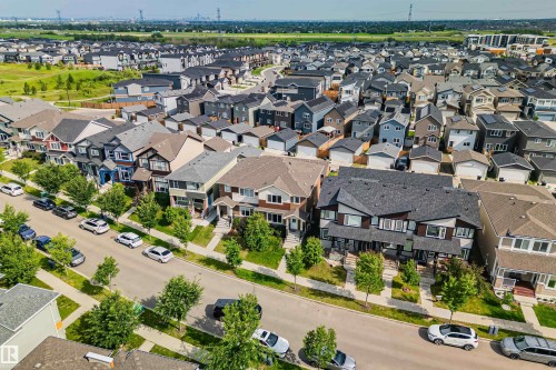 Residential neighborhood featuring a variety of detached homes and townhomes with distinct architectural styles, individual front yards, paved streets, and numerous mature trees - 383 Charlesworth Drive, Edmonton, AB 