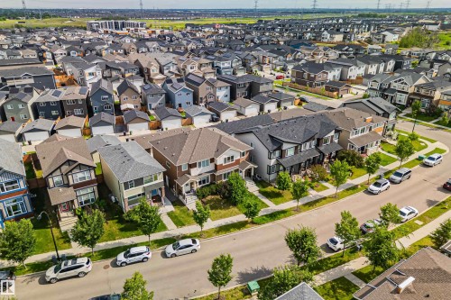 Modern residential development featuring multi-story homes with varied architectural styles, asphalt shingle roofs, and attached garages - 383 Charlesworth Drive, Edmonton, AB 