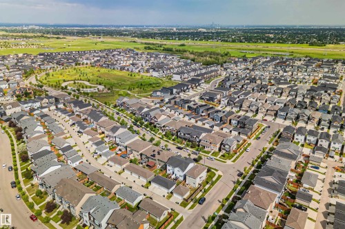 Aerial perspective showcasing a residential neighborhood with varied architectural styles, curvilinear street patterns, and ample green space - 383 Charlesworth Drive, Edmonton, AB 