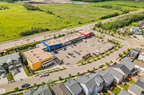 Aerial depiction of a commercial development surrounded by residential properties and green spaces - 383 Charlesworth Drive, Edmonton, AB 