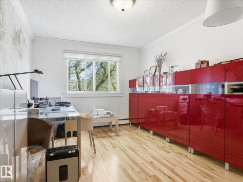 Bright room featuring light wood-finish flooring, white walls, and a large window with white blinds - 301 10003 87 Avenue, Edmonton, AB - Indoor