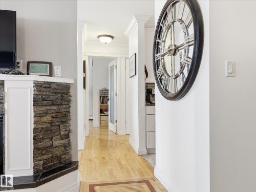 Hallway featuring light wood-finish flooring with a decorative inlay, crown molding, and a flush-mount ceiling light - 301 10003 87 Avenue, Edmonton, AB - Indoor Photo Showing Other Room