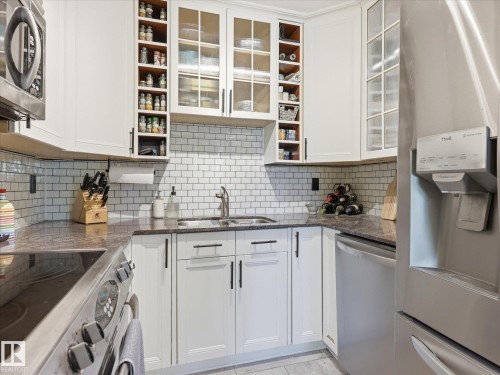 Contemporary kitchen with white cabinetry and dark hardware - 301 10003 87 Avenue, Edmonton, AB - Indoor Photo Showing Kitchen With Double Sink With Upgraded Kitchen