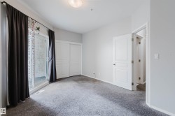Carpeted interior space featuring a sliding glass door, white trim, a built-in closet with sliding doors, and a paneled interior door - 
