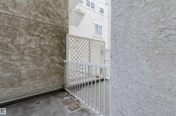 Private patio space featuring a lattice privacy screen and white metal railing - 