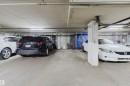 Underground parking garage featuring concrete flooring, exposed overhead piping, fluorescent lighting, and chain link storage units - 202 10939 82 Avenue, Edmonton, AB 