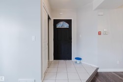 Foyer featuring a dark entry door with decorative glass, tile flooring, and a sliding closet door - 