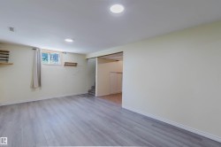Spacious room featuring wood-finish flooring, recessed lighting, and a window providing natural light - 