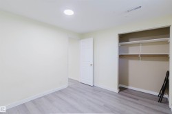 Room featuring wood-finish flooring, recessed ceiling lighting, a built-in closet with shelving and hanging rod, and a paneled interior door - 