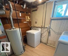 Utility area with a water heater, washer, and dryer - 