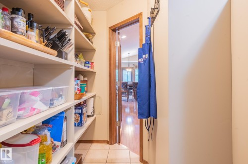 Pantry with built-in shelving, tiled flooring, and a wood-trimmed doorway - 19 Newton Place, St. Albert, AB - Indoor With Storage