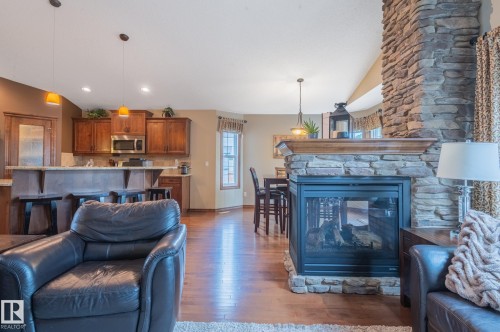 Stone-clad fireplace with a wood mantle - 19 Newton Place, St. Albert, AB - Indoor Photo Showing Living Room With Fireplace