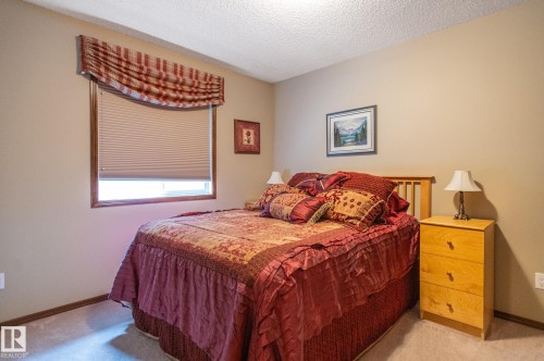 Neutral wall paint and textured ceiling complement the carpeted flooring - 19 Newton Place, St. Albert, AB - Indoor Photo Showing Bedroom
