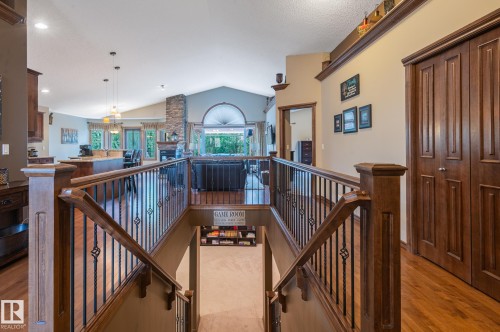 Hardwood flooring and custom wood newel posts with wrought iron balusters - 19 Newton Place, St. Albert, AB - Indoor Photo Showing Other Room
