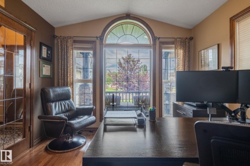Vaulted ceiling office space featuring a large arched window with transom detailing - 19 Newton Place, St. Albert, AB - Indoor