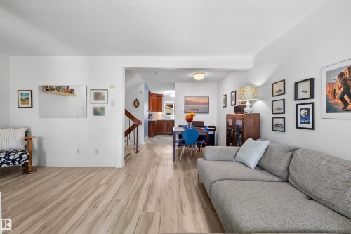 Open-concept living area with light wood-finish flooring extending throughout - 10940 123 Street, Edmonton, AB 